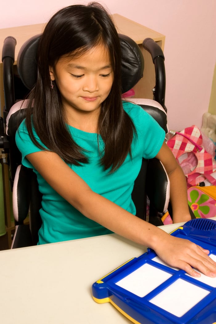 Disabled girl using assistive technology board